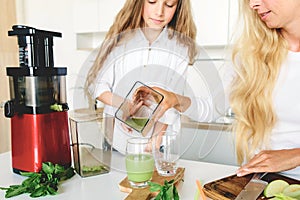 Cute little girl mother prepare healthy drink celery apple mint