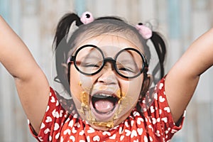 Cute little girl with mouth smeared with peanut butter.