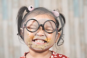 Cute little girl with mouth smeared with peanut butter. photo