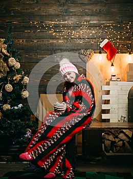 Cute little girl near Christmas tree. Kids Christmas. Happy small teenager in Santa hat with present have a Christmas