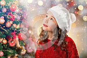 Cute little girl near Christmas tree. New Year card