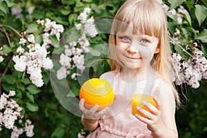 Cute little girl with orange juice and orange fruit, healthy drink