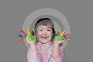 Cute little girl with painted hands. Isolated on grey background