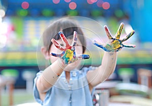 Cute little girl with painted hands, selective focus on hand