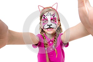 Cute little girl with painted mask on face making selfie