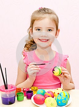 Cute little girl painting easter eggs
