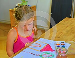 Cute little girl painting picture of house. Cute girl painting with watercolors. Mortage concept. Selective focus, small DOF