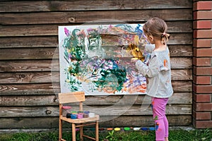 Cute little girl painting with various colors