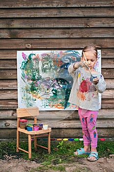 Cute little girl painting with various colors