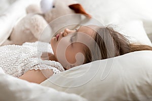 Cute little girl, peaceful child sleeping in bed with toy