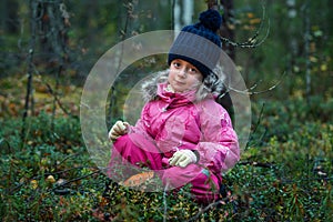 Cute little girl picking mushrooms