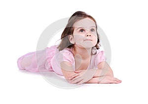 Cute little girl in a pink lie on the floor