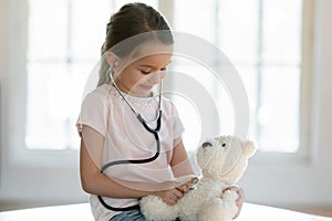 Cute little girl play hospital with teddy bear toy