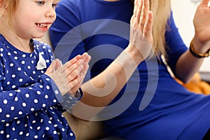 Cute little girl play with mom pat-a-cake