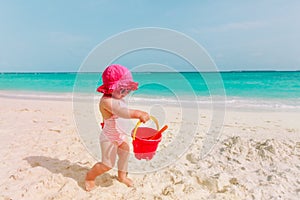 Cute little girl play with sand on beach