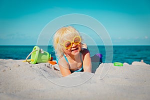Cute little girl play with sand on beach