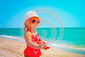 Cute little girl play with sand on beach