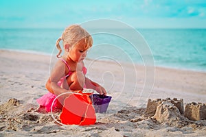 Cute little girl play with sand on beach