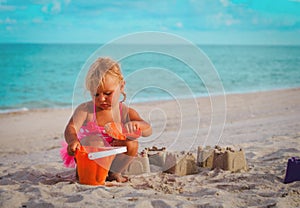 Cute little girl play with sand on beach