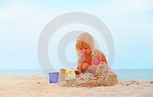 Cute little girl play with sand on beach