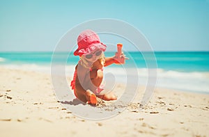 Cute little girl play with sand on beach