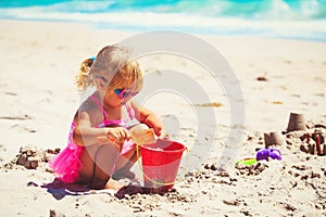 Cute little girl play with sand on beach