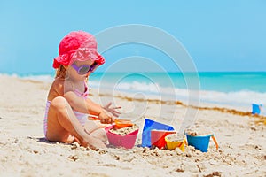 Cute little girl play with sand on beach