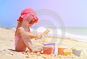 Cute little girl play with sand on beach