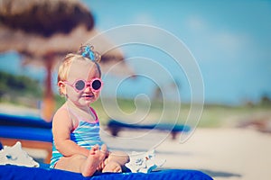 Cute little girl play with seashells on beach