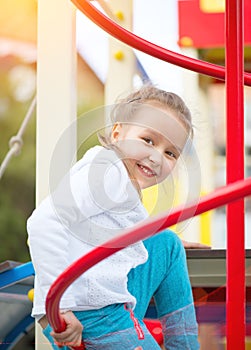 Cute little girl on the playground. Outdoor portrait of five years old girl looking at camera