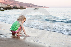 Cute little girl playing on the beach