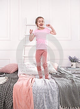 Cute little girl playing on the bed