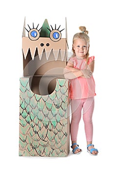 Cute little girl playing with cardboard dragon
