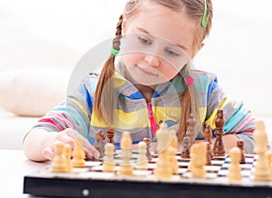 Cute little girl playing chess