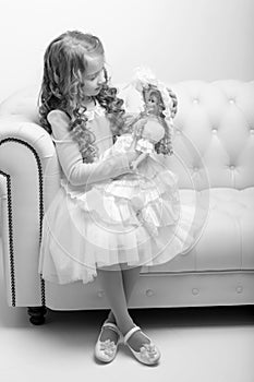 Cute little girl playing with a doll.