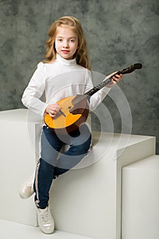 Cute little girl is playing dombra.