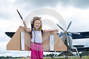 A cute little girl playing on the field by a four-seater private jet dreaming of becoming a pilot