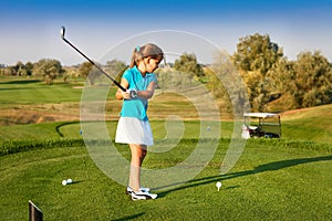 Cute little girl playing golf on a field outdoor