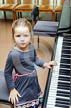 Cute little girl playing grand piano