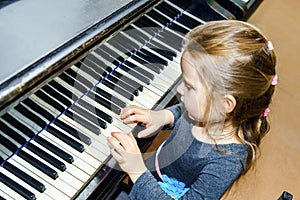 Cute little girl playing grand piano