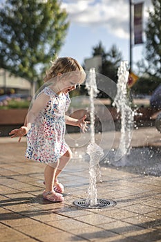 Cute Little Girl Playing Happy at City Fountain