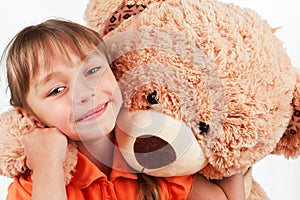 Cute little girl playing with her friend big fur bear