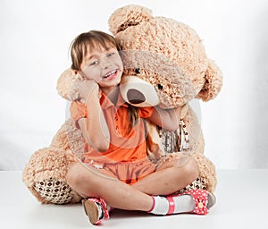 Cute little girl playing with her friend big fur bear