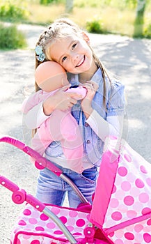 Cute little girl playing with her toy carriage