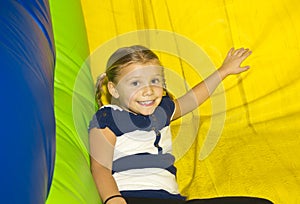 Cute little Girl playing on inflatable Slide photo