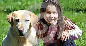 Cute little girl playing with labrador retriever dog