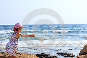 Cute Little girl is playing and  looking at the wide sea at summer