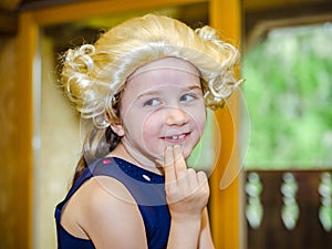 Cute little girl playing piano, dressing in retro Mozart periwig