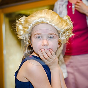 Cute little girl playing piano, dressing in retro Mozart periwig