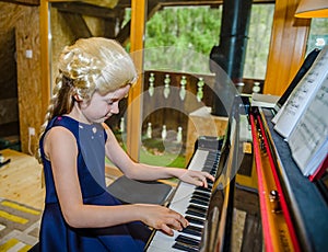 Cute little girl playing piano, dressing in retro Mozart periwig